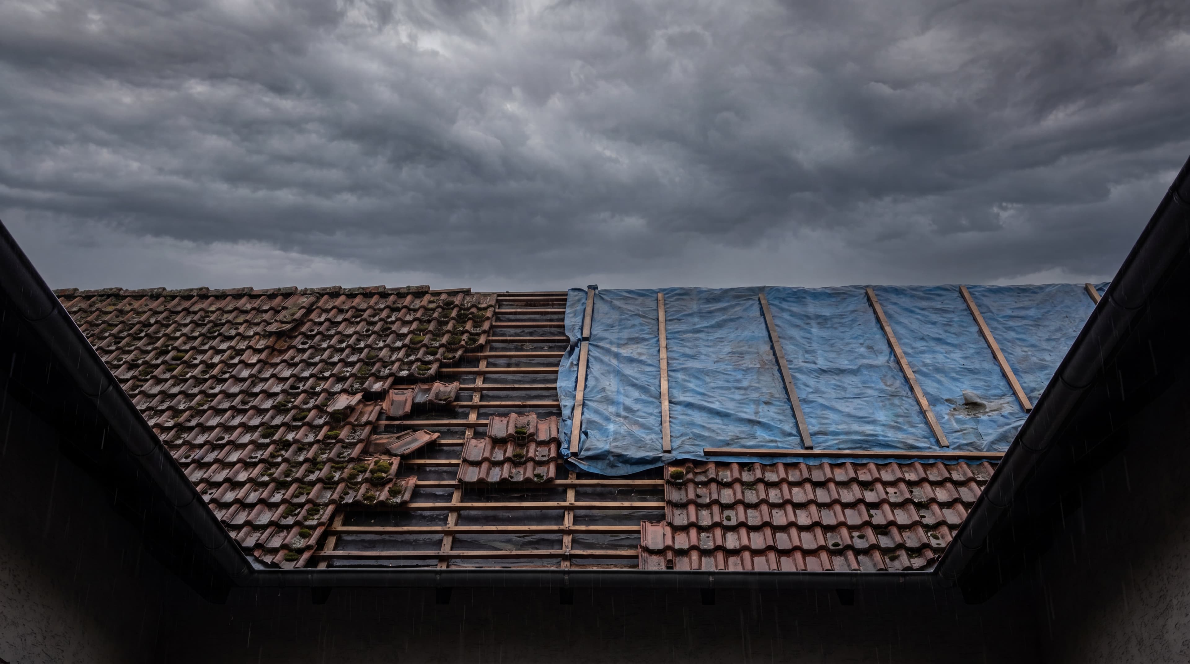 Dach mit Sturmschaden bei aufziehendem Unwetter